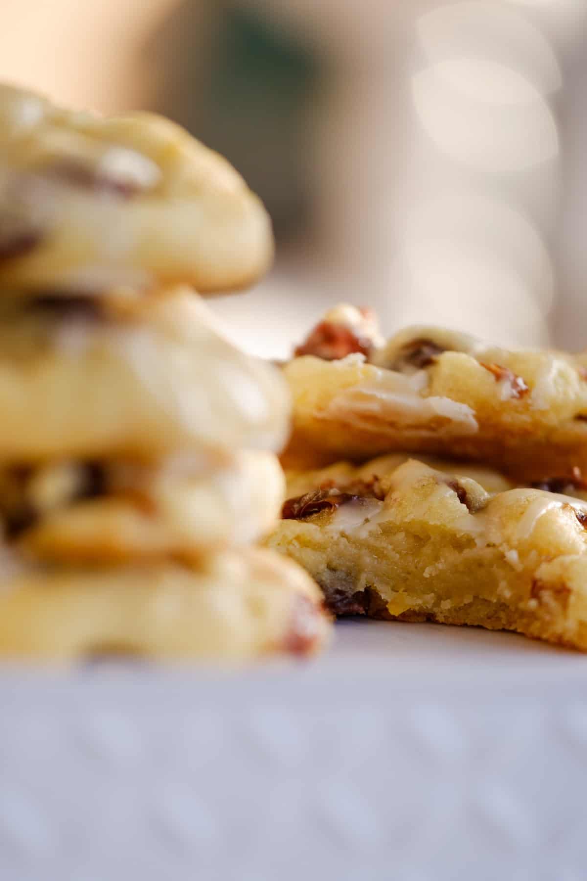 2 stacks of iced orange rum raisin cookies, one stack has a cookie with a missing bite