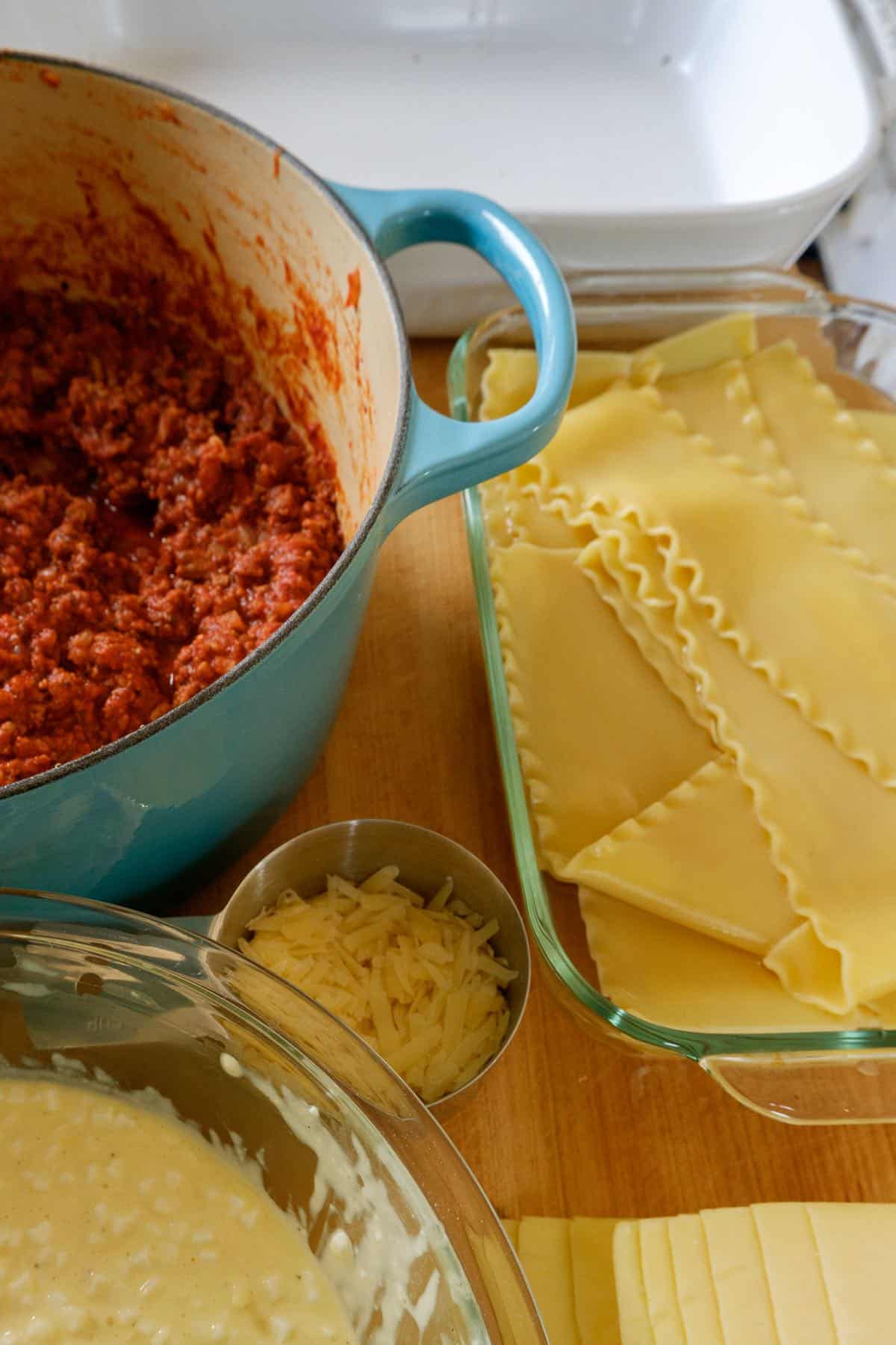 lasagna ingredients ready to layer in the white pan