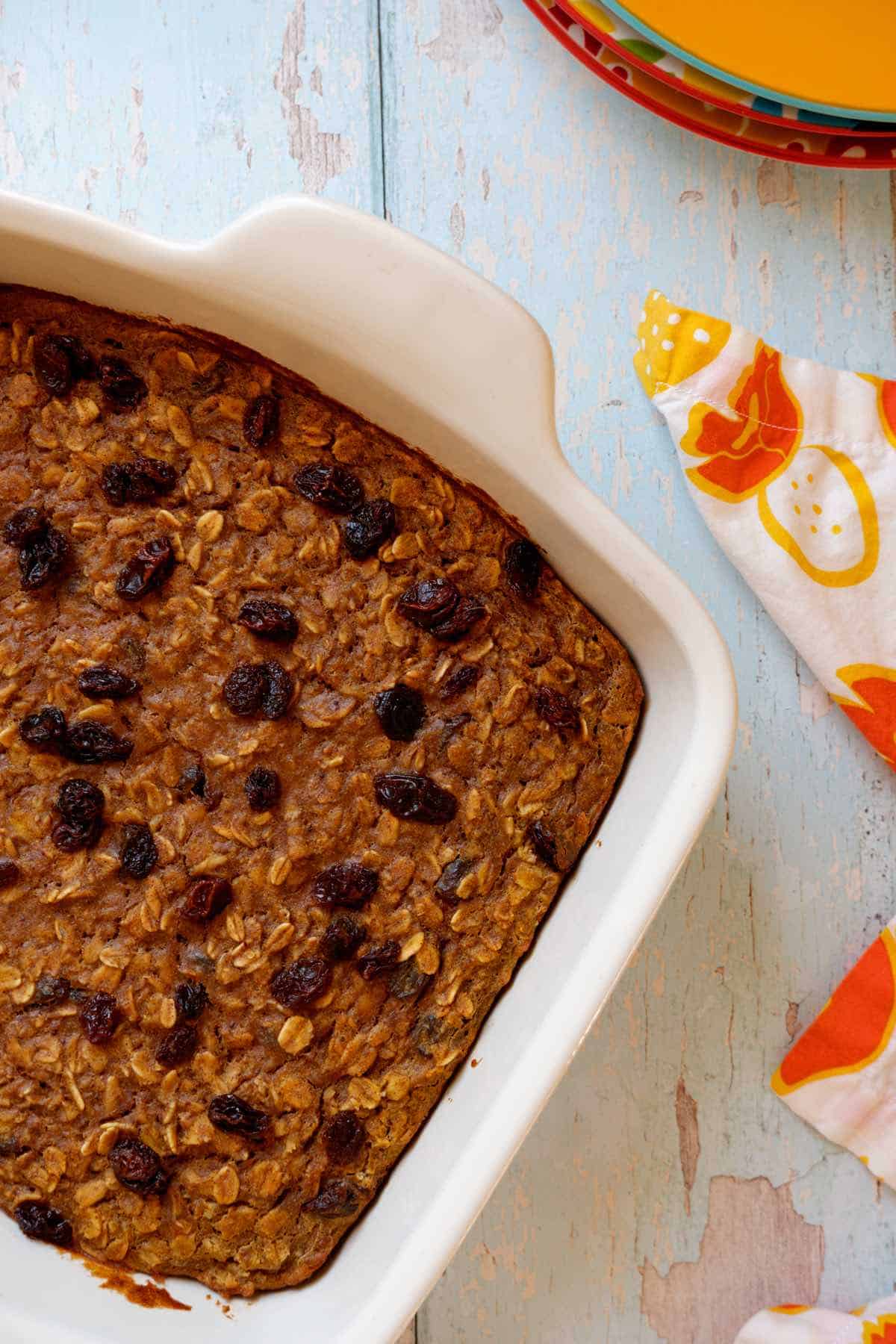 protein baked oats in white pan next to orange flowered napkin